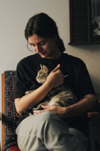 A smiling woman holding a cat.